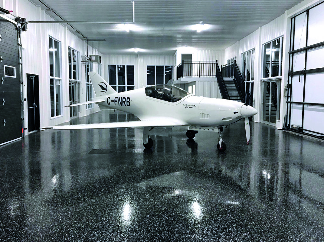 Aircraft hangar with high-gloss PurEpoxy black speckled epoxy floor coating