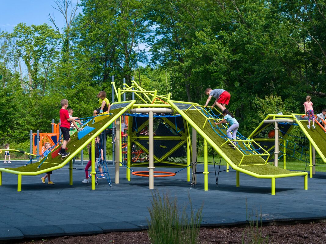 Modern commercial playground in park recreation area with safety surfacing