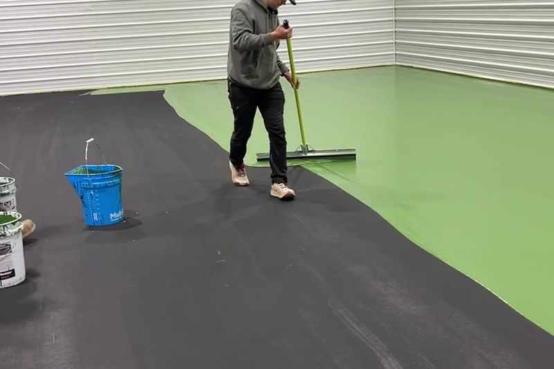 Crew member squeegeeing the base coat on the indoor slab
