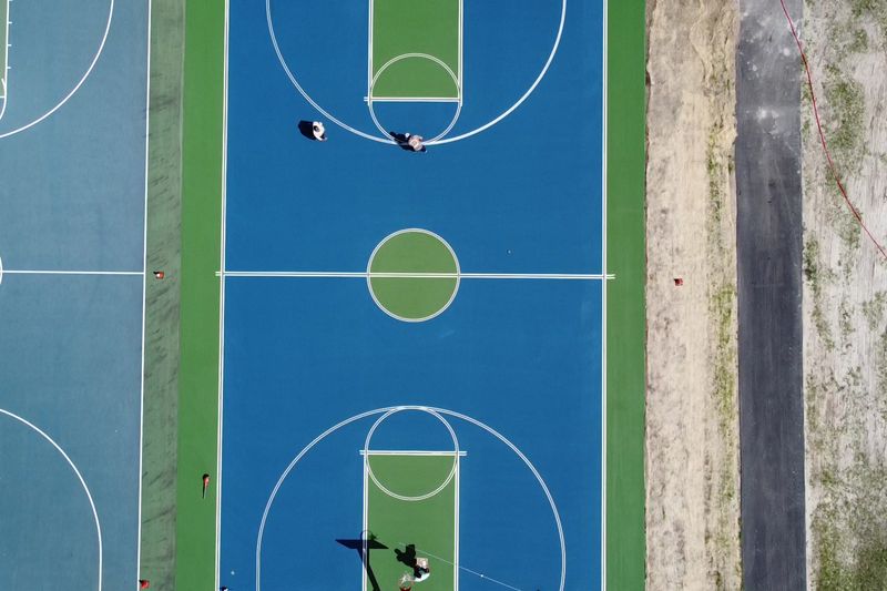 Overhead of one court with crew finishing line work
