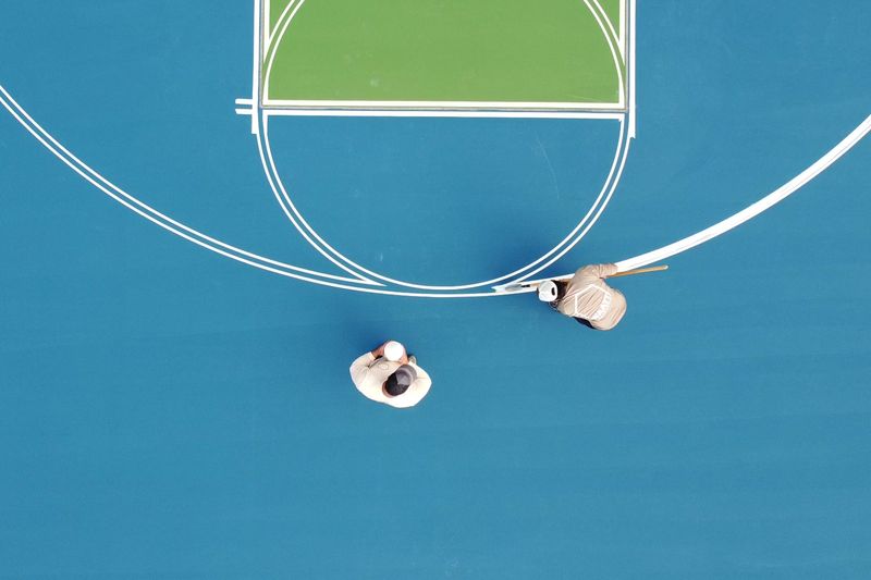 Overhead of crew striping the key and three-point line
