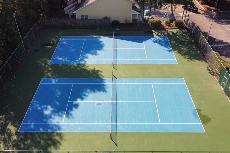 Aerial of two side-by-side tennis courts with blended lines