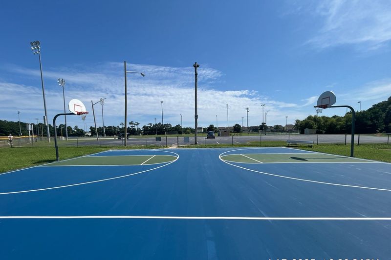 Blue basketball court with white lines and goals
