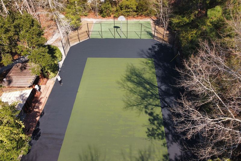 Aerial of the court with the green surround coated and the playing area still black