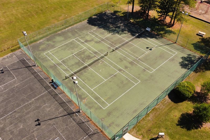 Before: discolored court with moss and failing lines, aerial view