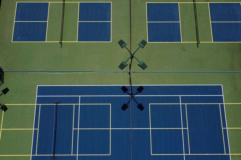 Overhead view of blended tennis and pickleball lines on a two-tone blue court