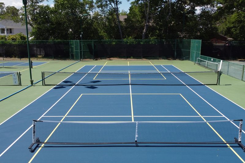 Finished tennis court with pickleball lines seen from behind the net